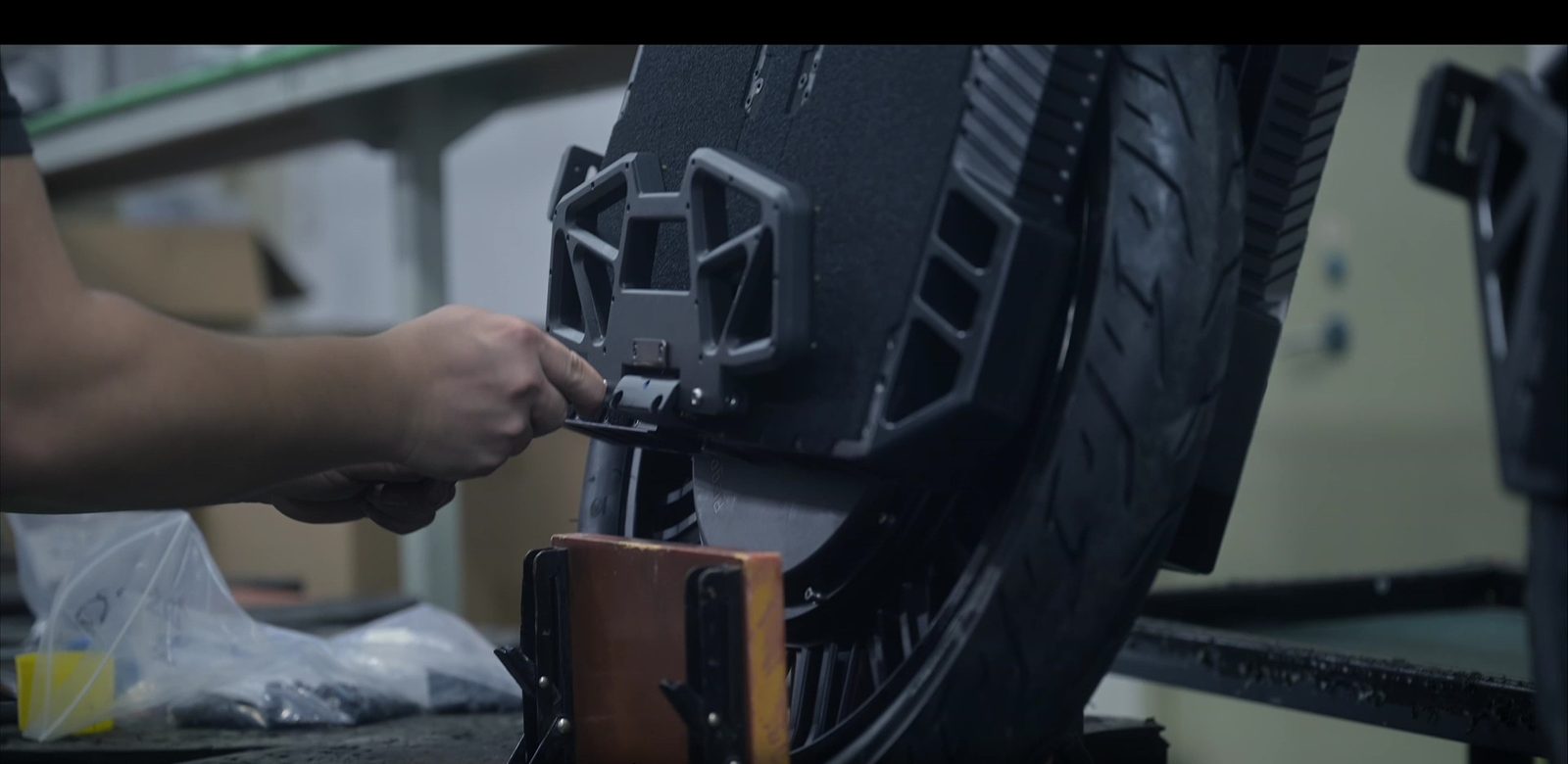 Begode technician fitting motor and structural components during wheel assembly