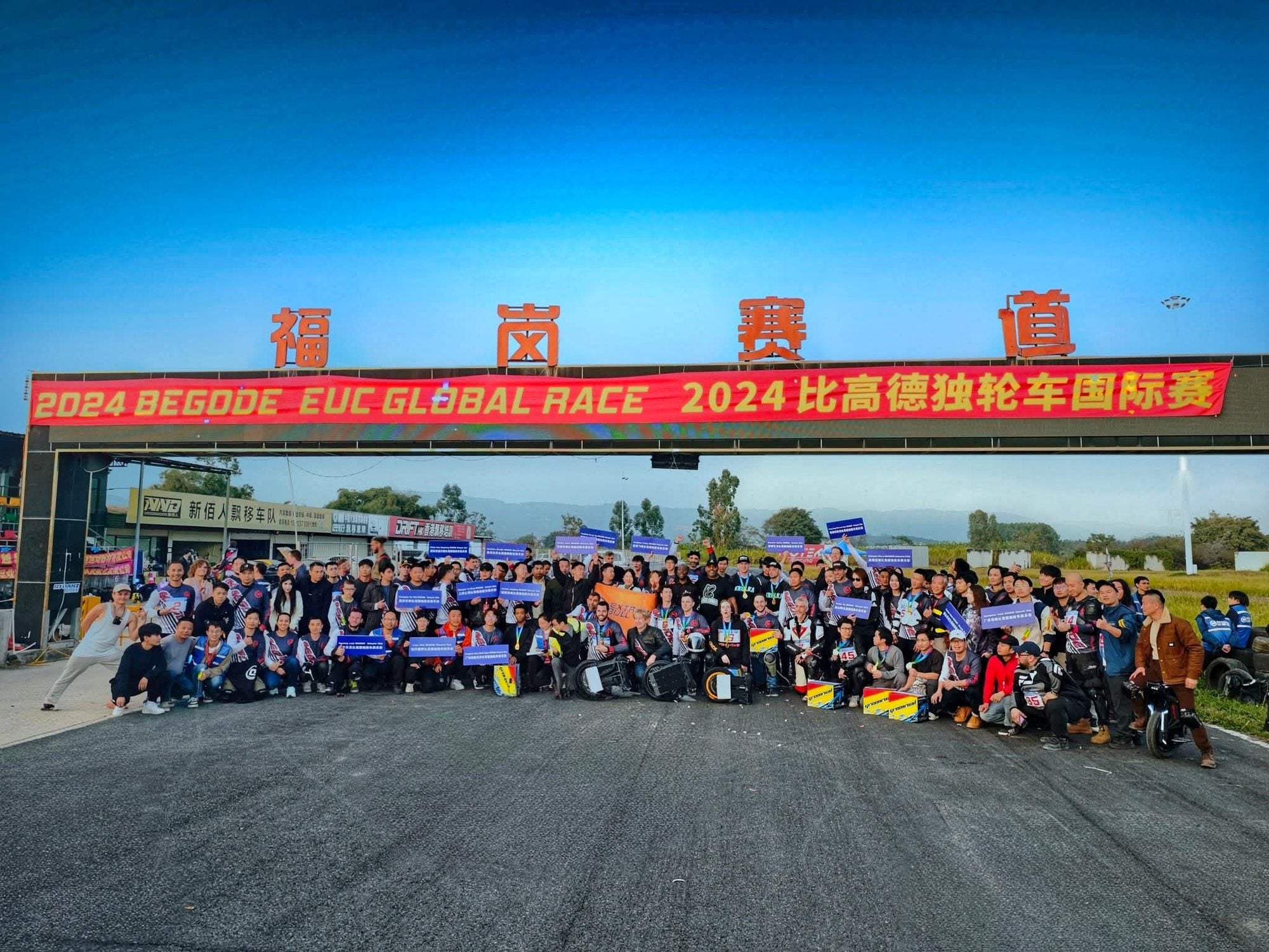 Large group photograph beneath the Begode  EUC GLOBAL RACE banner in 2024